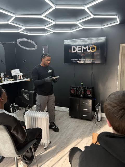 Interior of MJay's Barbershop with hex lighting and two chairs